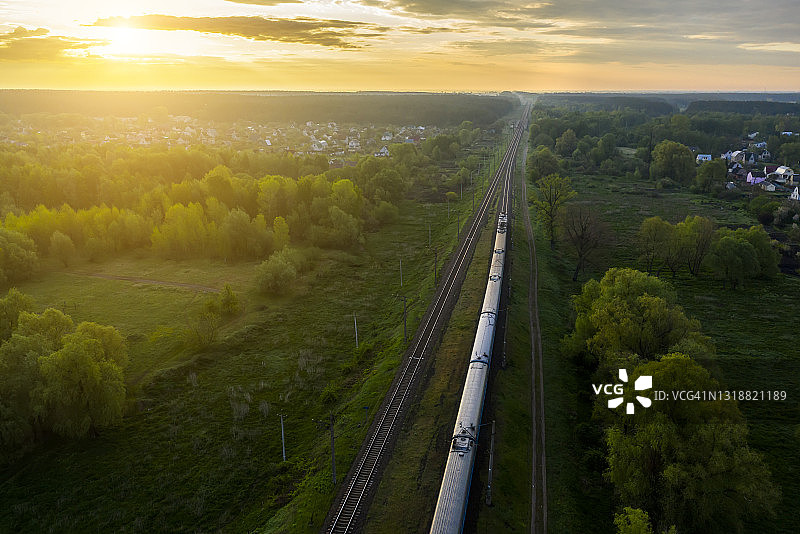 日出时铁路上的一列货运火车。鸟瞰图图片素材