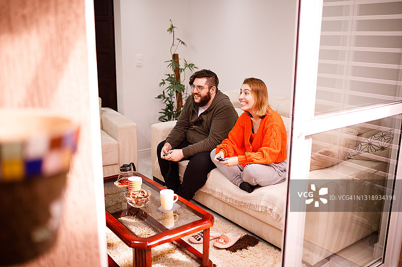 一对情侣在客厅一起玩电子游戏图片素材
