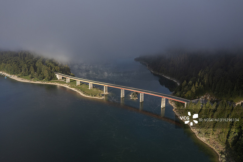 鸟瞰图上的桥湖与雾在秋天。Sylvensteinspeicher, Sylvenstein水库，Bad Tölz-Wolfratshausen，上巴伐利亚，巴伐利亚，巴伐利亚阿尔卑斯山，德国。图片素材