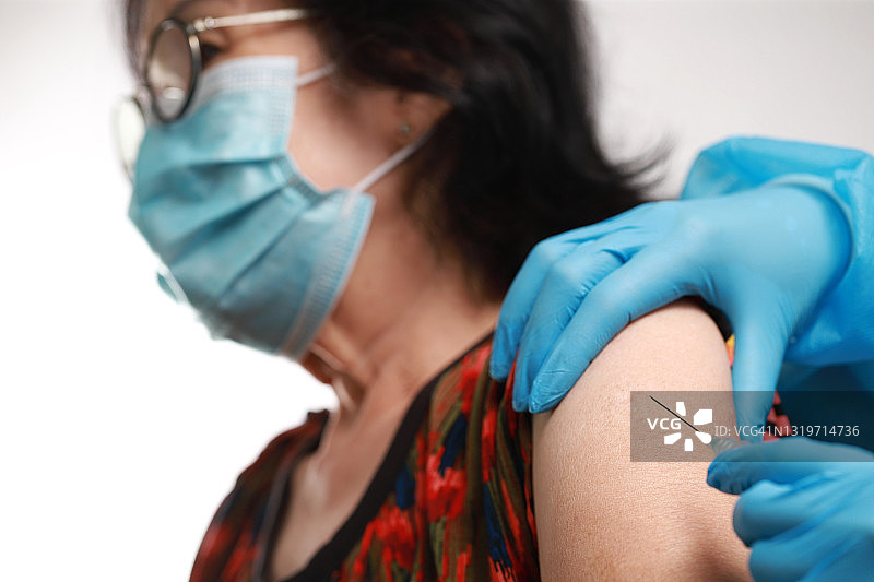 注射器针头和疫苗在护士手中。老年冠状病毒疫苗的研制图片素材