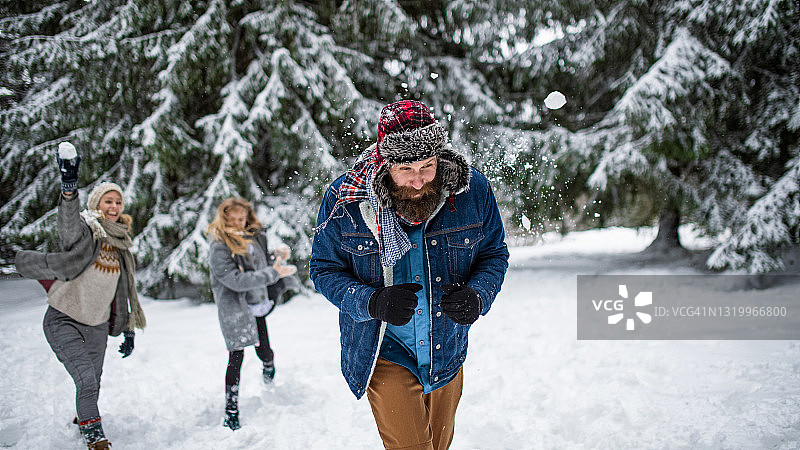 父母带着小女儿在雪地里散步，打雪仗。图片素材