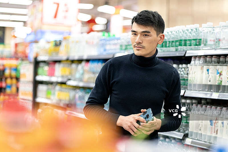 超市里的亚洲年轻男性顾客图片素材