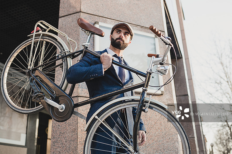 一个在街上扛着自行车的商人图片素材