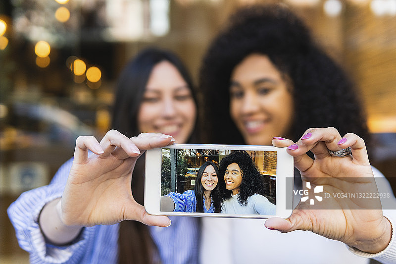 女性朋友在智能手机上展示自拍图片素材