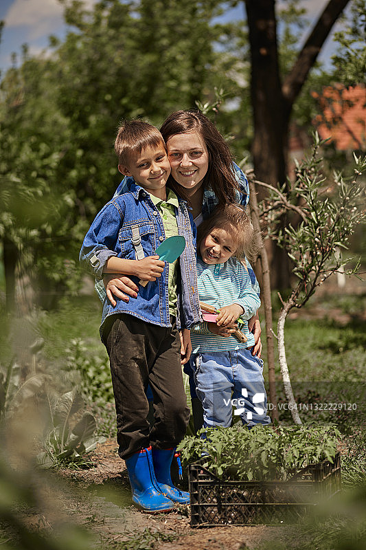 微笑的母亲与儿子和女儿在后院图片素材