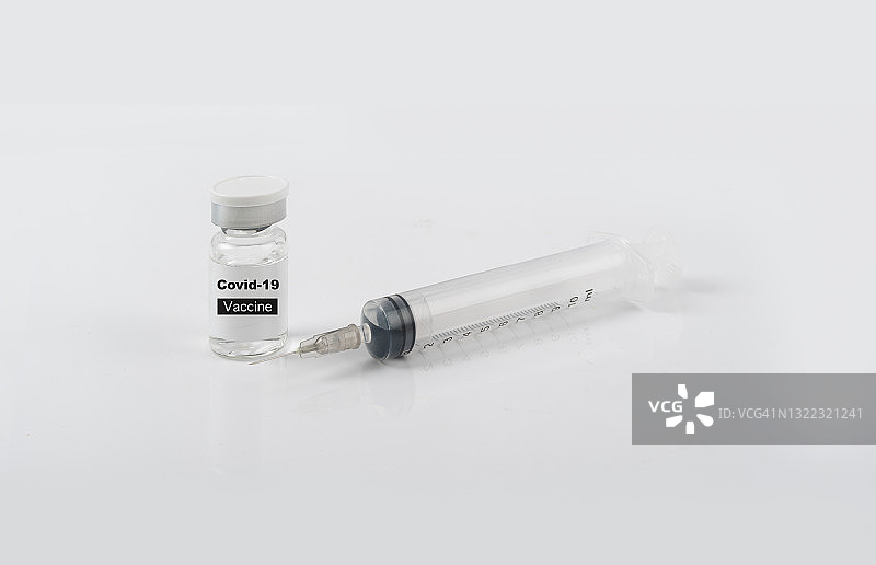 医用玻璃小瓶和塑料注射器，放置在白色桌子上，蓝色背景渐变。欧洲联盟疫苗接种的概念。副本的空间。图片素材