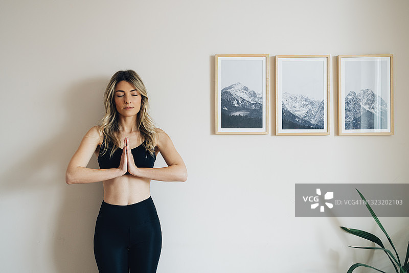 内心的平静:女人在合十礼瑜伽姿势图片素材