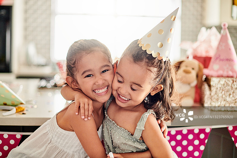 一个女孩拥抱她的妹妹在她生日的照片图片素材