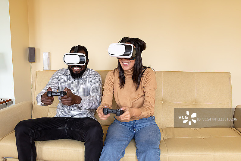 微笑的亚洲女人和她英俊的非洲男朋友正在用虚拟现实眼镜浏览一个虚拟世界。图片素材