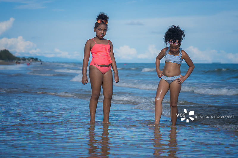 两个非洲裔美国孩子在海滩上。图片素材