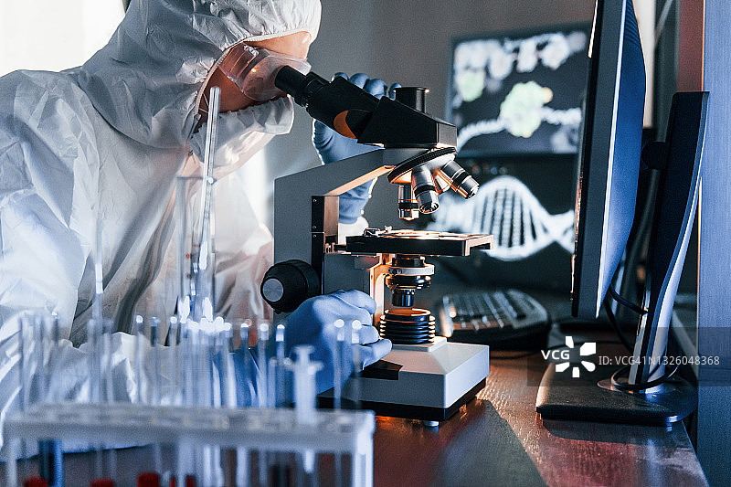 身穿白色防护服的科学家在实验室处理冠状病毒和血管图片素材