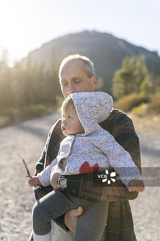 慈爱的祖父和他一岁的孙女在大自然中享受时光图片素材