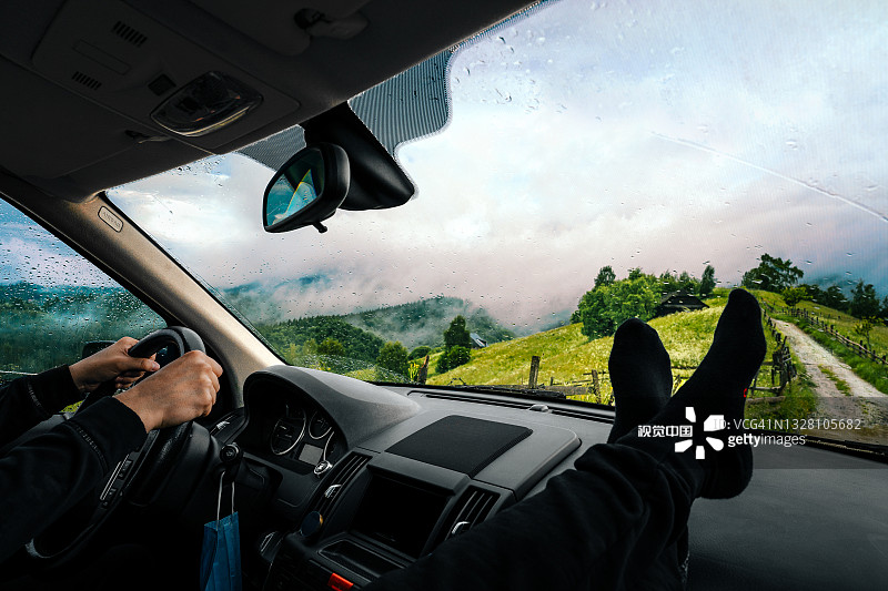 一个人在夏天雾蒙蒙的山路上开车。乘汽车旅行的人图片素材
