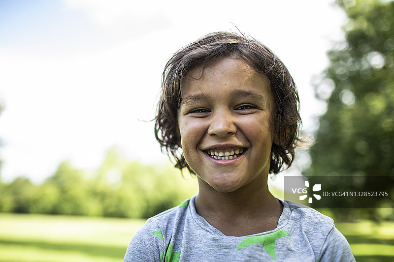 小男孩在公园微笑的肖像图片素材