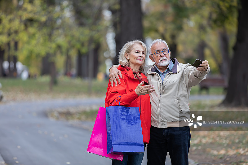 一个上了年纪的女人和她的丈夫在公园里散步，度过了美好的一天。图片素材