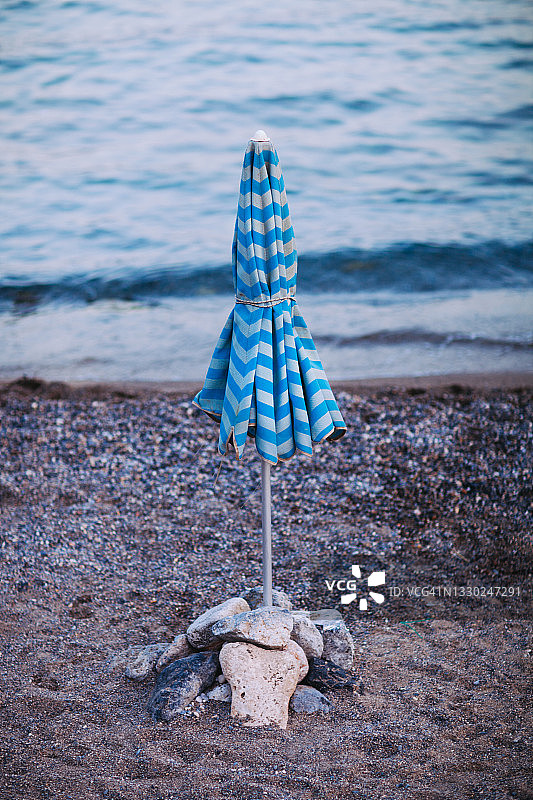 把阳伞绑在空荡荡的沙滩上图片素材