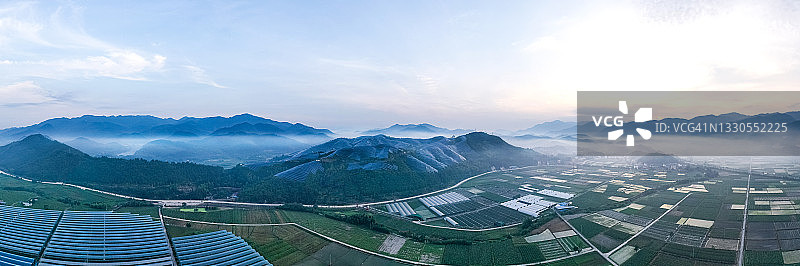 清晨鸟瞰壮丽的农场和山顶的太阳能发电站图片素材
