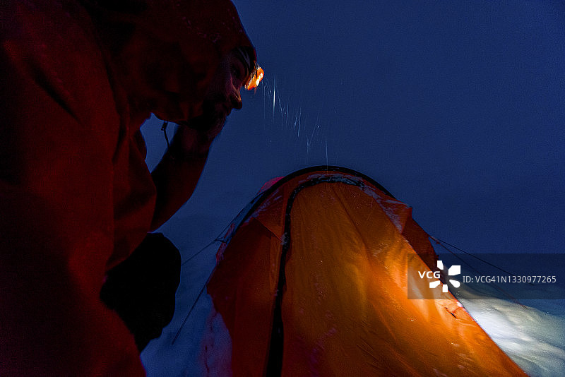 在加拿大落基山脉，一名年轻人走向帐篷图片素材