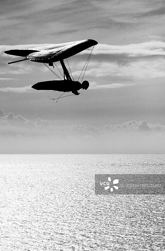 一名男子驾驶滑翔机在太平洋上空翱翔。图片素材