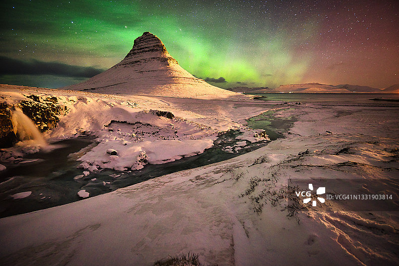 著名的柯克朱山在一个晴朗的夜晚与北极光在冰岛西部，冰岛冬季图片素材