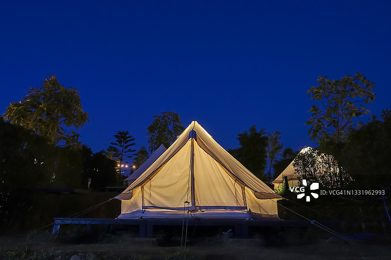 晚上，白色帐篷在花园里扎营图片素材