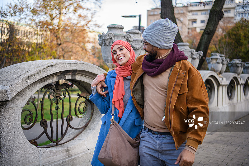 一个非洲男人和一个穆斯林女人在公园里恋爱。图片素材