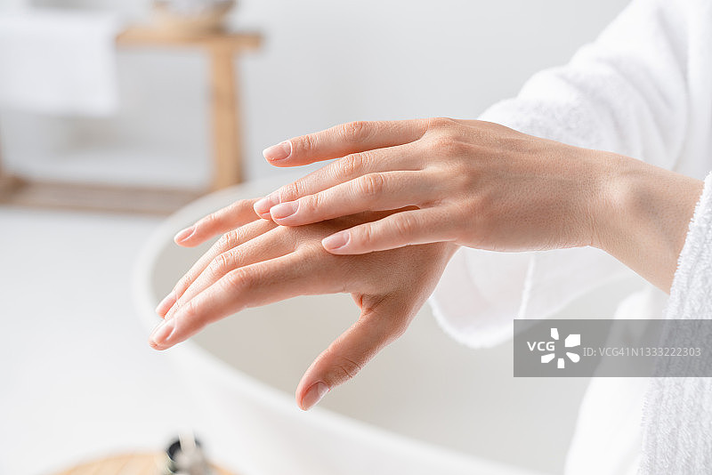 在水疗中心，年轻女性的手在涂抹润肤霜和身体油，以达到平滑效果。家身体保健。美休闲治疗图片素材