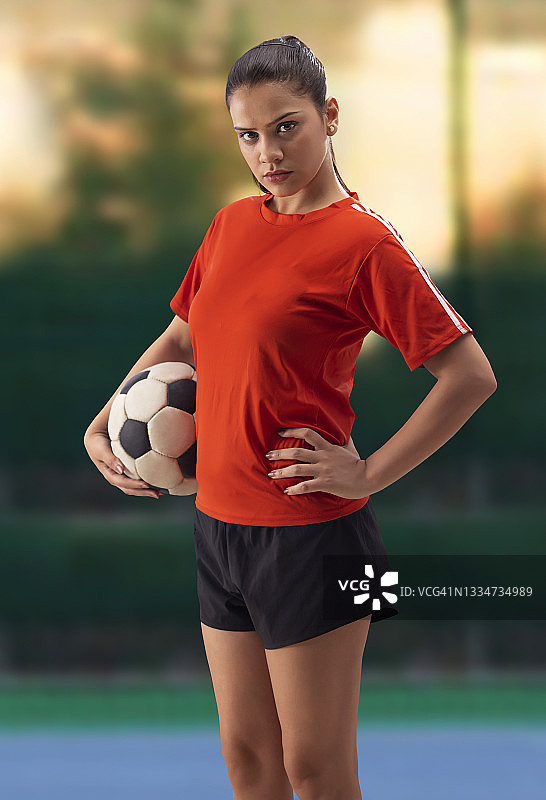 一个自信的女足球运动员站在镜头前图片素材