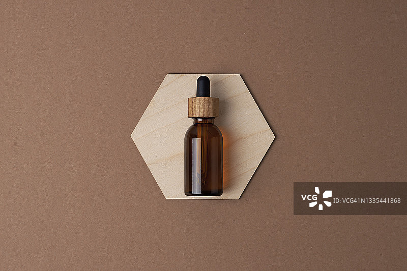 棕色背景的木制六边形化妆品瓶。平铺，复制空间图片素材