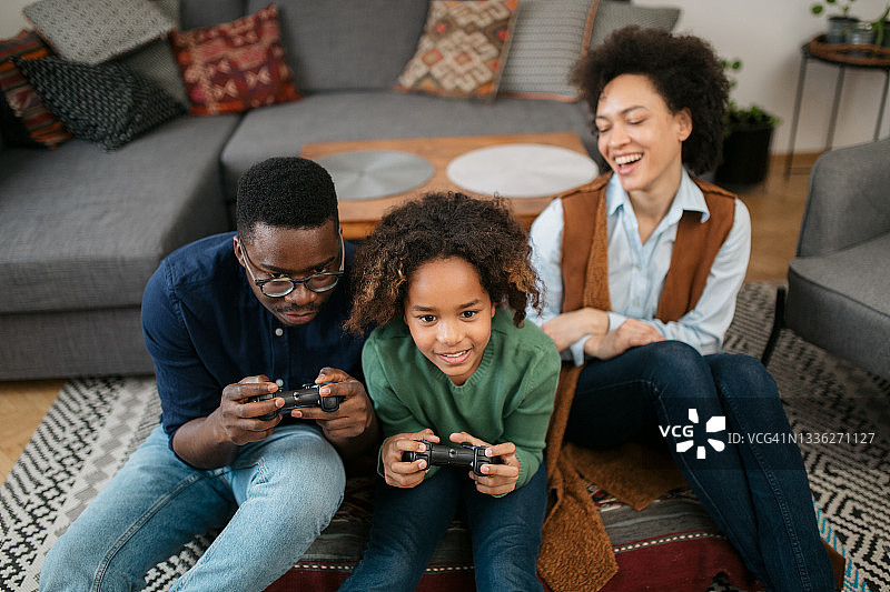一个快乐的非裔美国家庭在家里玩电子游戏的高视角图片素材