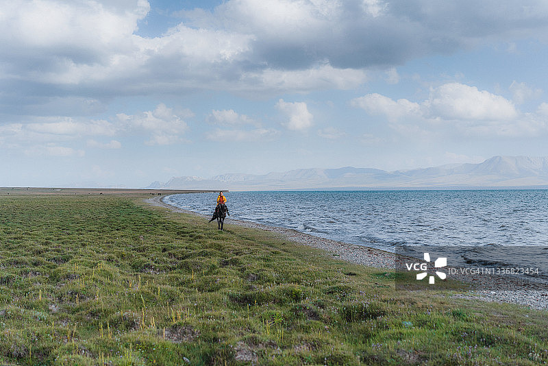 在吉尔吉斯斯坦的孙古尔湖附近，一名女子骑着马图片素材