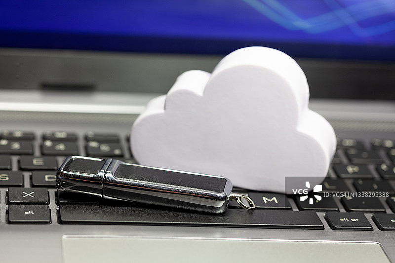 云数据存储技术，将数据抽象存储在云中。云和usb记忆棒，笔驱动器放在笔记本电脑键盘上。在线私人个人数据备份服务技术简单概念图片素材