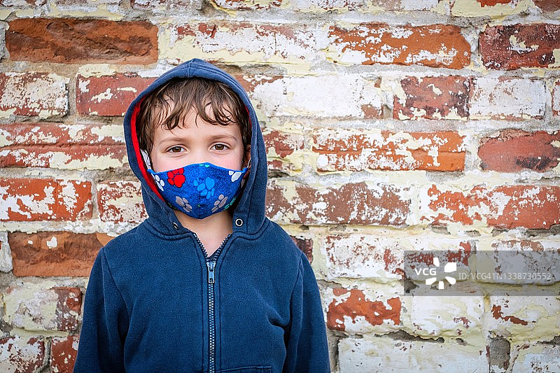 一个恼怒的小学生戴着防护面罩看着镜头图片素材