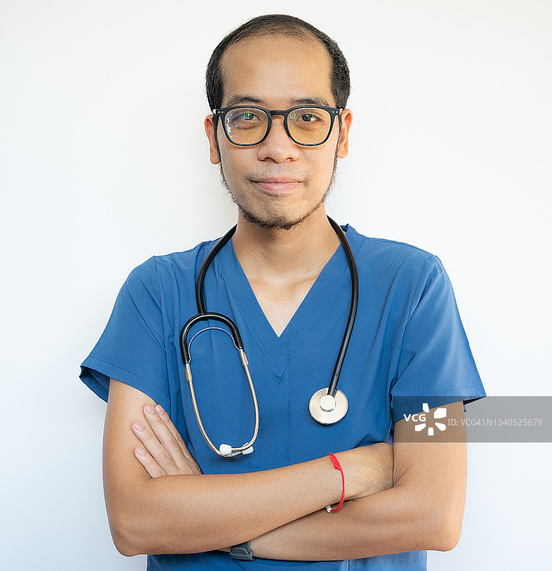 自信的亚洲男性医护人员，他交叉双臂，准备在医院工作。图片素材