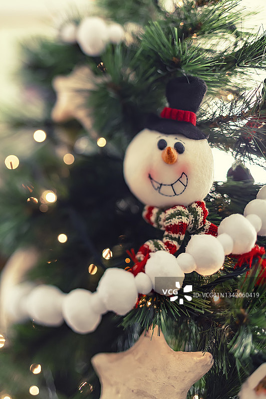 圣诞装饰品的特写镜头挂在家里的树上。图片素材