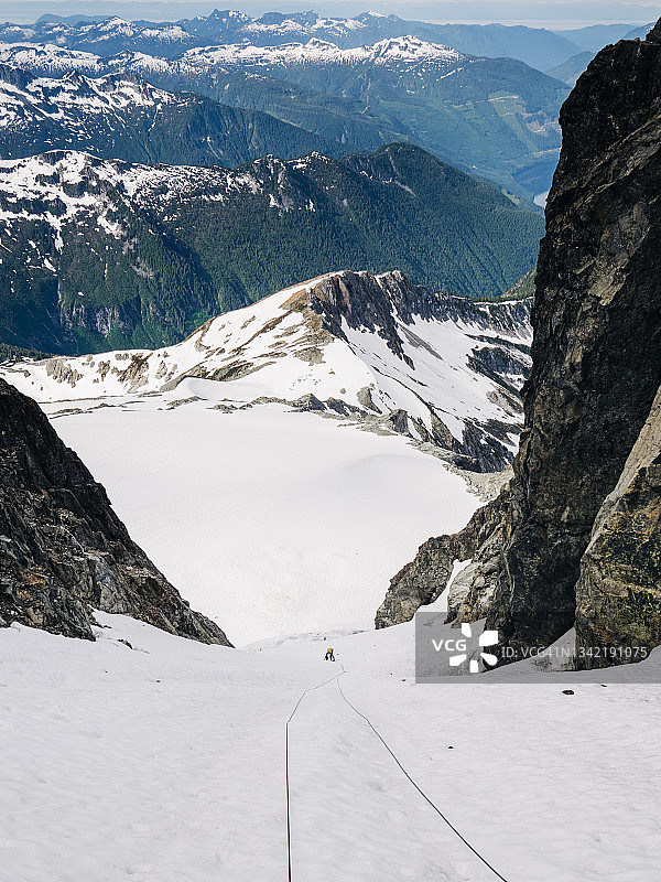 一个冰上的攀登者正在爬一条巨大的雪沟图片素材