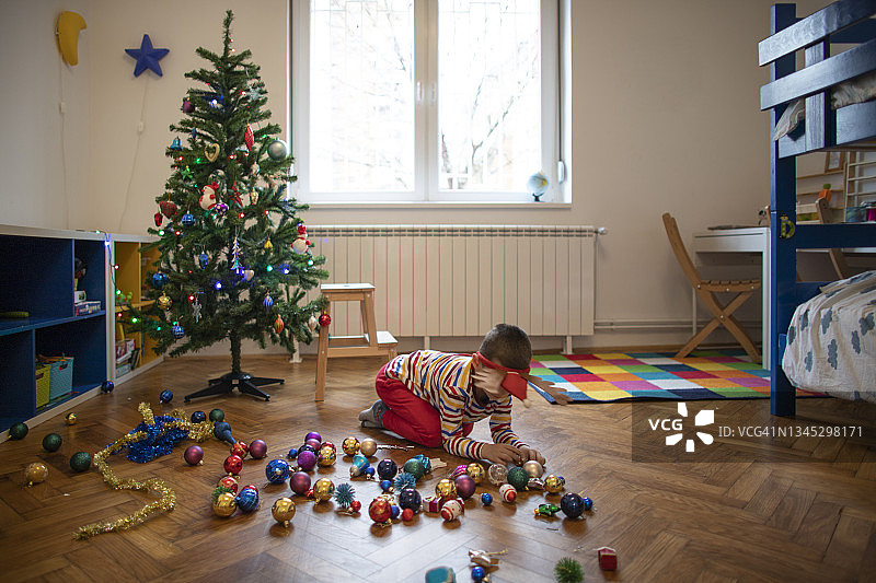男孩在玩耍和装饰圣诞树图片素材