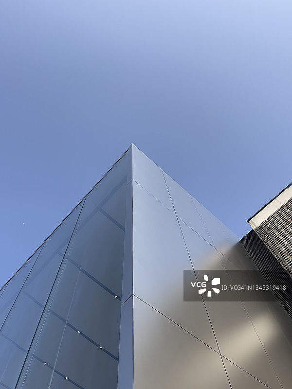 蓝天下银色现代建筑的正面图片素材