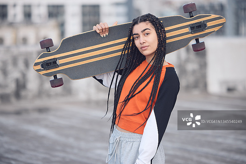 一名年轻女子在城市里玩滑板图片素材