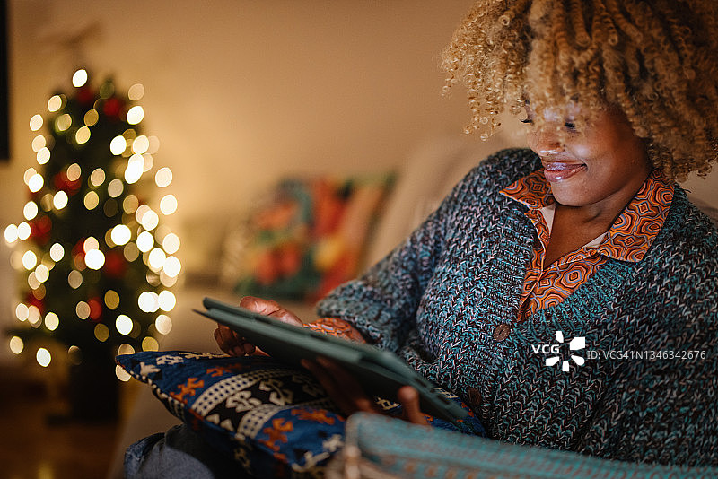 一名女子在她的电子平板电脑上进行圣诞网上购物图片素材