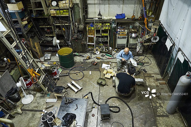 父子俩在一家小型焊接工厂工作图片素材