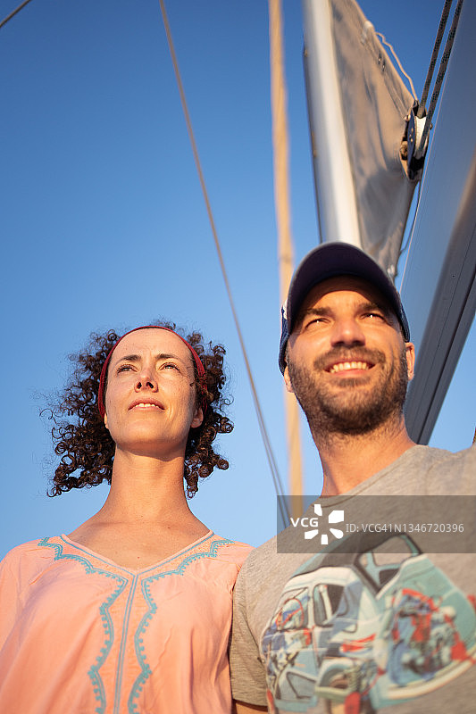 一对夫妇在日落时一起站在甲板上图片素材