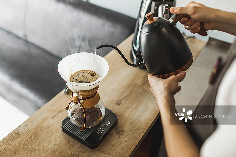 咖啡师手工将水从水壶倒入过滤咖啡机chemex图片素材