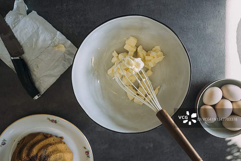 头顶拍摄的碗黄油和搅拌器在厨房台面图片素材