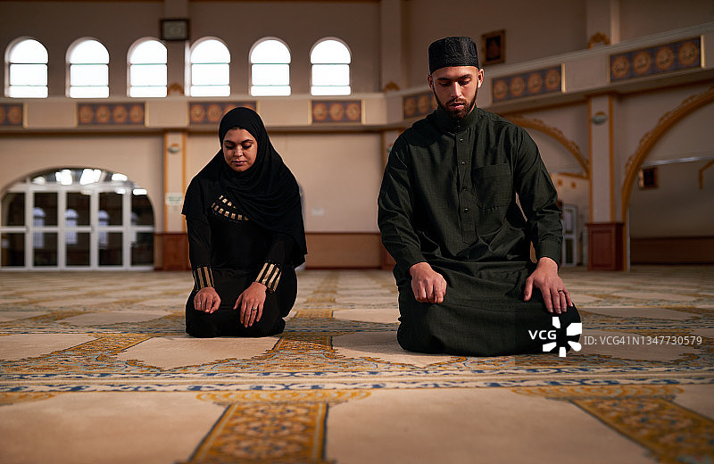 一对年轻的穆斯林夫妇在清真寺里一起祈祷图片素材