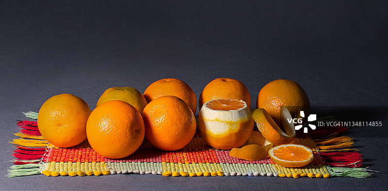 一串橙子排在一条流行色毛巾上。图片素材