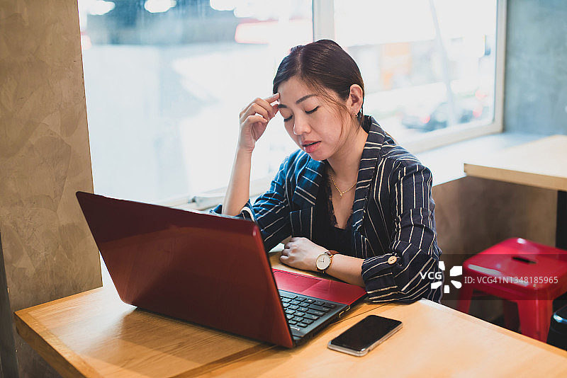 压力和过度工作的女性商业主管与笔记本电脑图片素材