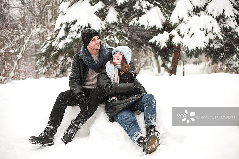 幸福的年轻夫妇，女人和男人花时间在户外的雪天在公园图片素材