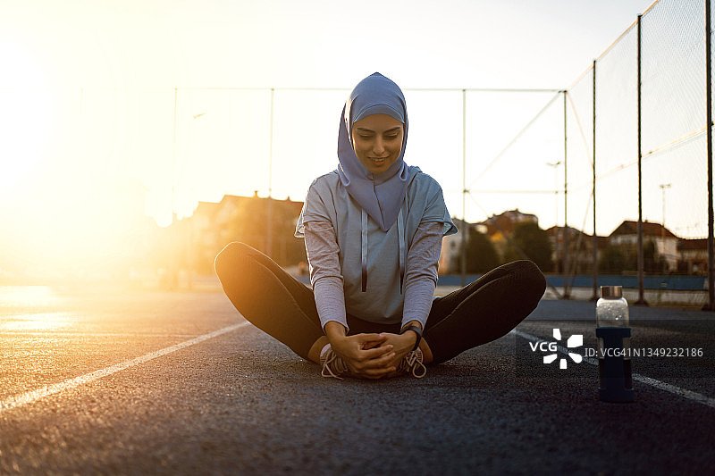 经过激烈的训练，穆斯林女运动员正在伸腿图片素材