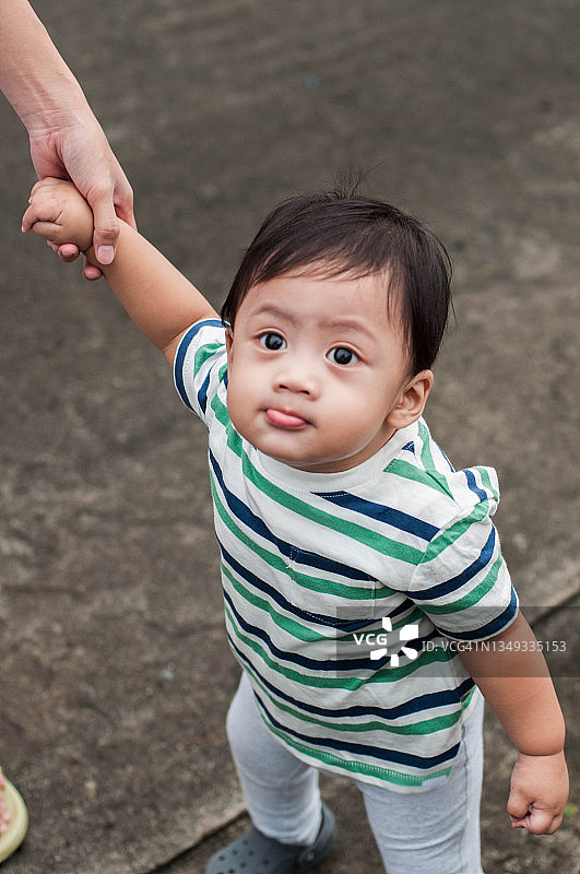 一名东南亚男婴正在学习户外行走图片素材